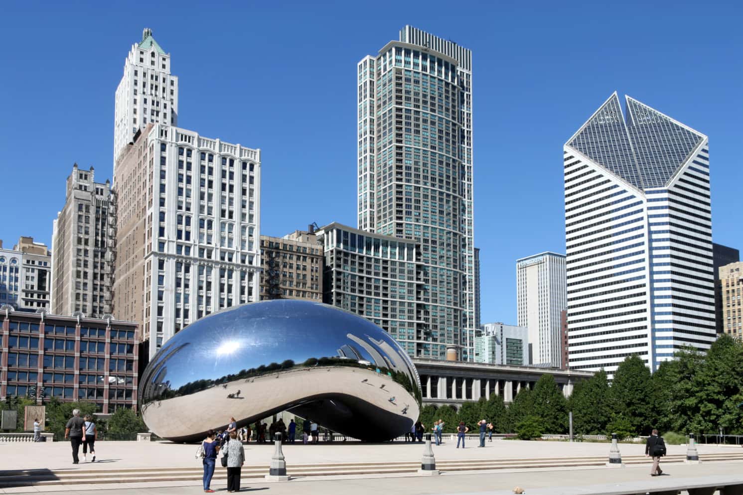 The Cloud Gate sculpture, aka "The Bean", in Millennium Park Chicago with the historic Michigan Avenue "streetwall" in the background