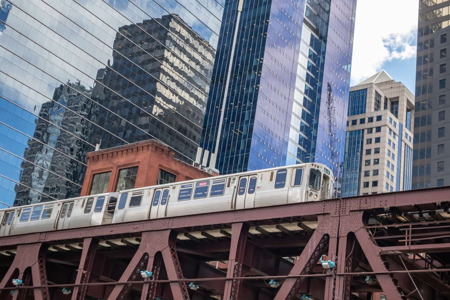 Chicago's iconic "L" train running on elevated tracks surrounded by skyscrapers in downtown Chicago