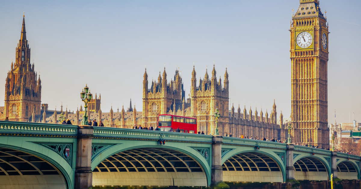 Red double-decker bus crossing Westminster Bridge, with Big Ben in the background