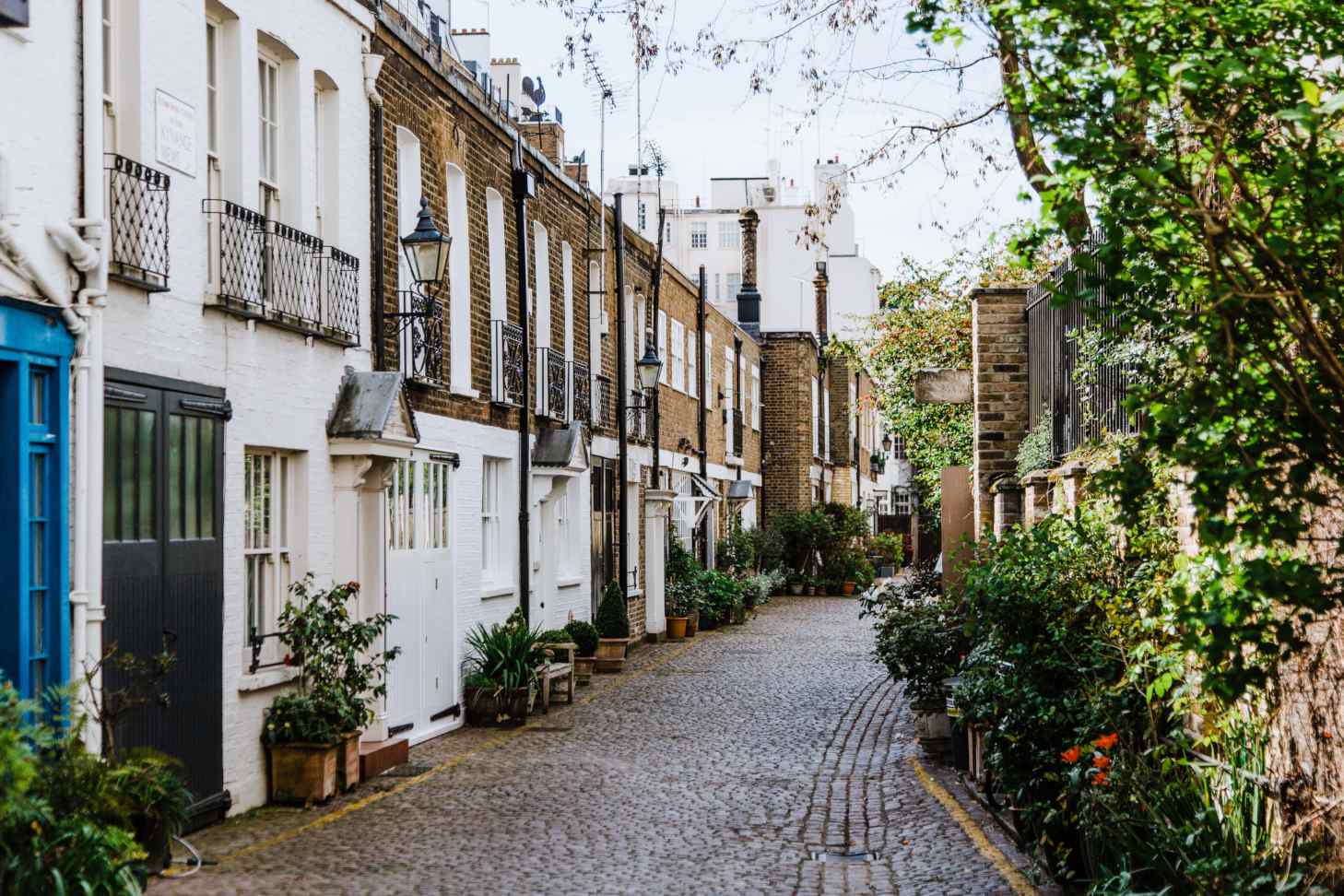 Row of typical London houses along a brown pavement road