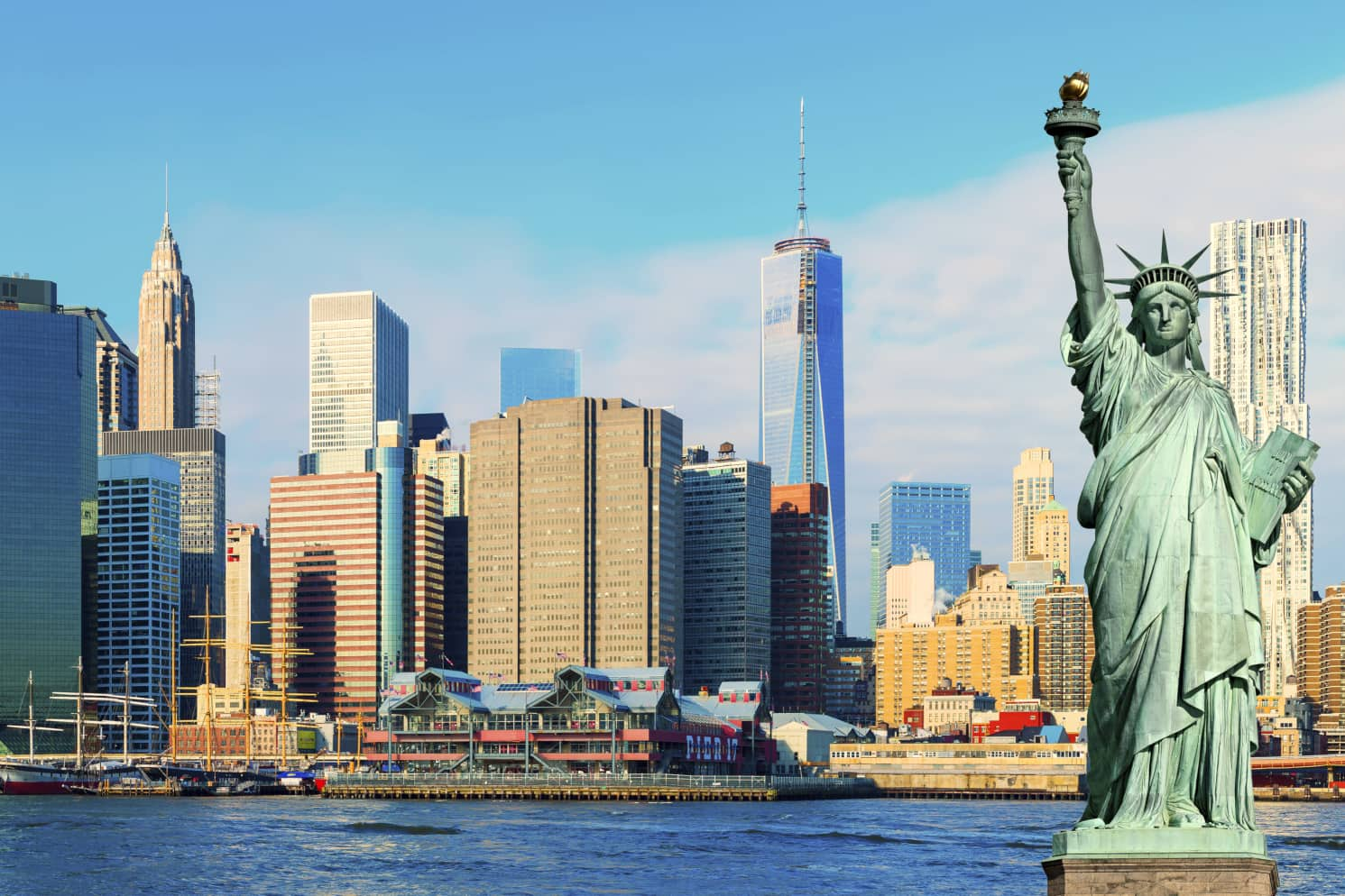 Skyline of Manhattan on a clear day with the Statue of Liberty in the foreground