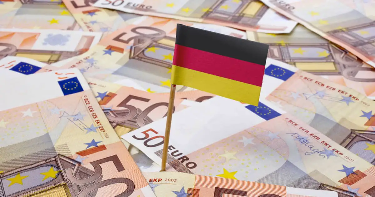Miniature flag of Germany on top of a pile of Euro banknotes