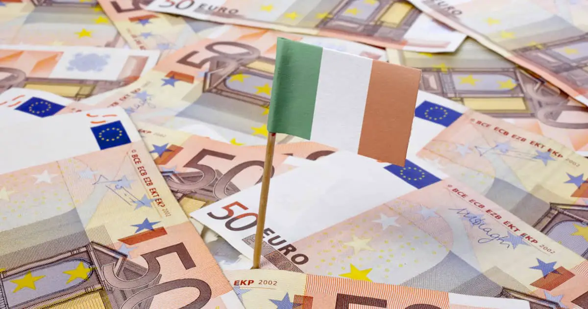 Miniature flag of Ireland on top of a pile of Euro banknotes